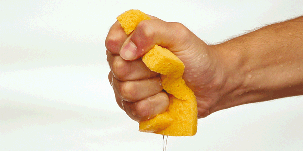 Hand squeezing wet sponge